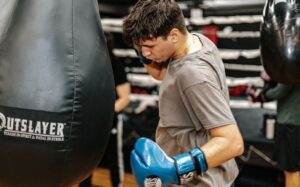 An athlete hitting a haavy boxing bag