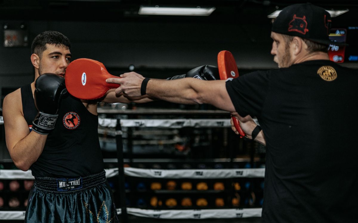 Boxing coach instructing student in the boxing ring