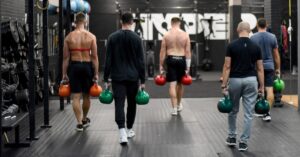 Guys in a fitness group setting caring KB