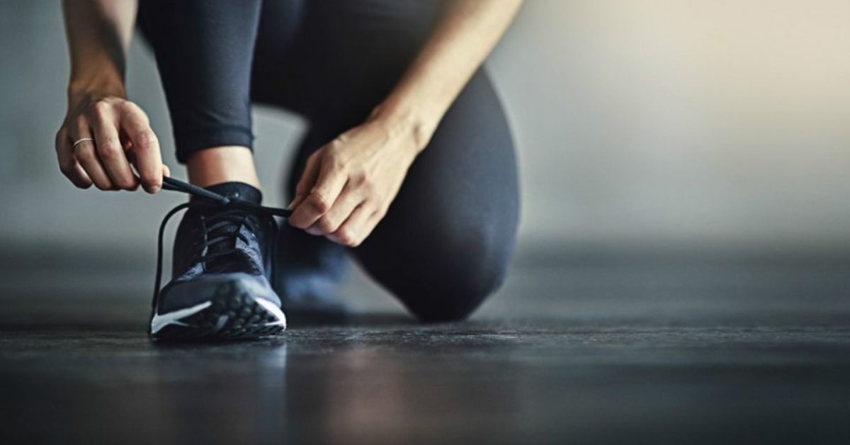 Girl tying her running shoe